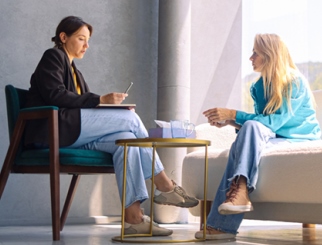 Female patient and therapist talking in a sunny office.