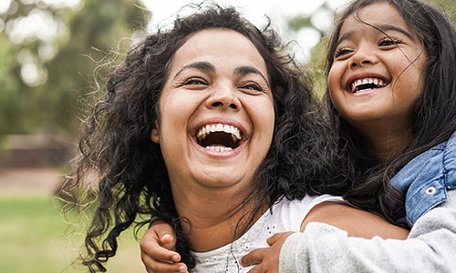 Una madre feliz y sonriente con su hija en un parque.