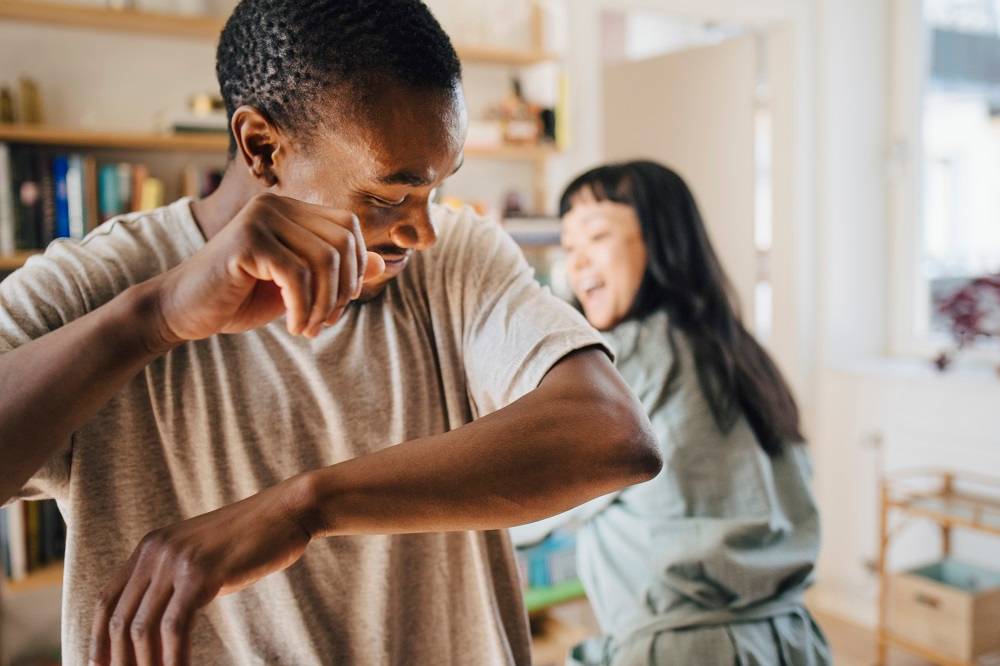 Young man and woman dancing at home after finding BCBSNM health insurance.