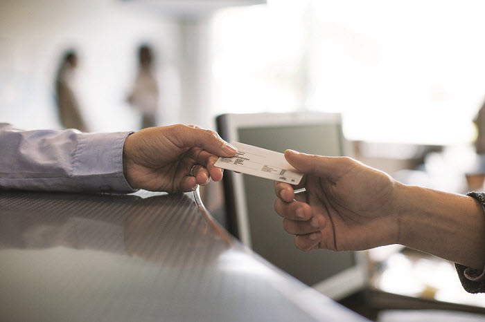 A man handing his insurance card to an employee