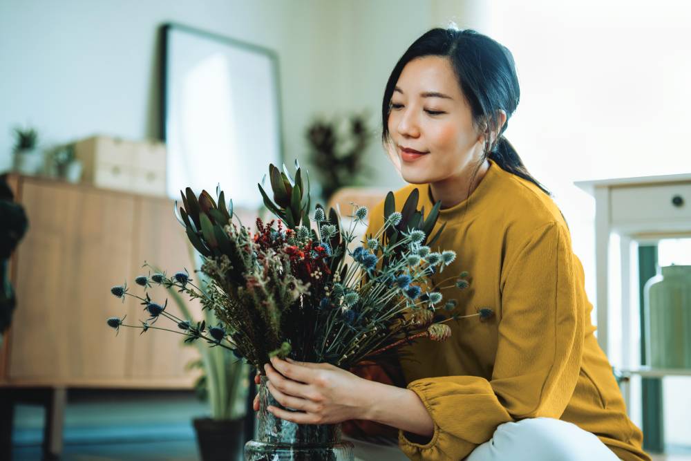 Woman putting a bouquet of flowers in a vase.