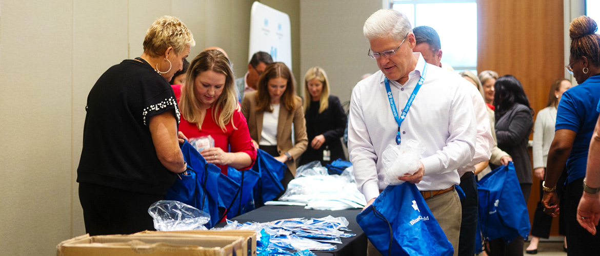 Executives at Blue Cross and Blue Shield of Texas fill bags to give away